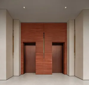 The image depicts a modern lobby featuring concrete walls and wooden elevator doors.