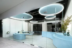 A modern minimalist reception desk made of concrete in a glass-walled corporate office setting.