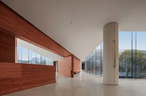 Modern office lobby with concrete walls and large windows.