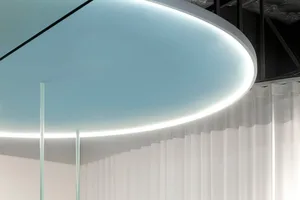 Modern office space featuring transparent glass curtains and a sleek, minimalist design.
