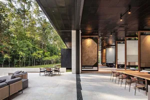 An open-plan modern showroom interior featuring minimalist design with concrete and wood materials.