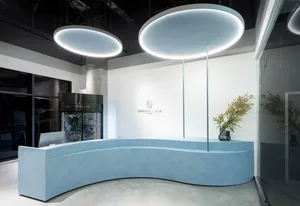 簡潔的極簡主義接待桌採用混凝土材質，具備曲線造型與整合式燈光設計。