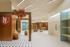 Modern retail storefront with potted plants, floral decorations, and a welcoming entrance.