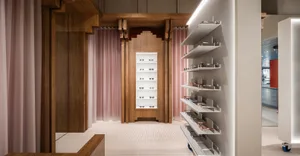 A modern retail interior featuring glasses on shelving and a wooden design aesthetic.