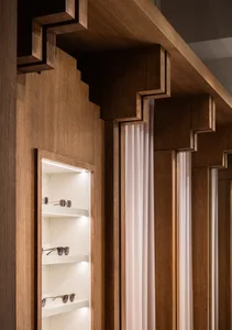 A modern retail shop showcasing wooden shelves with sunglasses.