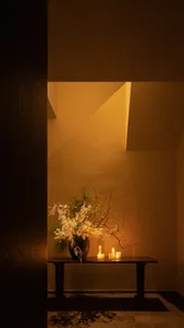 A decorative table with flowers and candles, creating a warm and inviting atmosphere.
