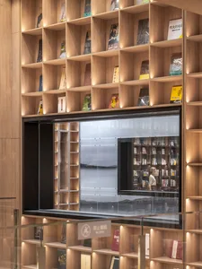 A modern bookstore interior with wooden shelves and a glass wall reflecting the outside.