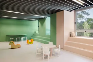 A modern child playroom features soft, green, and white materials and furniture.
