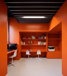 A modern office space featuring color-blocked walls and a spacious work area with two white chairs, a desk, shelves, and a pr
