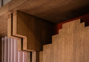 Modern residential interior space featuring polished wooden walls and geometric wood carvings.