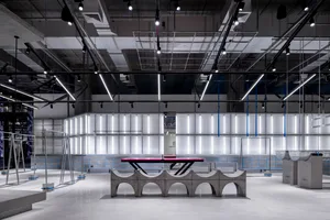 A modern industrial interior space featuring concrete materials, white lighting, and minimalist design.
