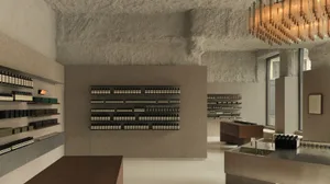 A minimalist retail storefront with concrete walls, shelves filled with products, and a large chandelier.