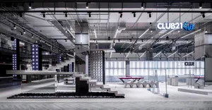 A minimalist retail interior with concrete elements and industrial lighting.