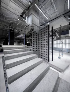 A modern commercial space with exposed concrete walls and a staircase.
