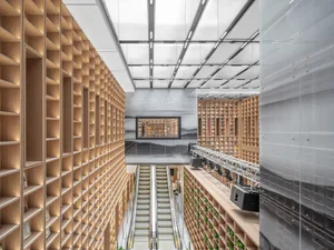 Photo of a spacious library with wooden shelves and modern design elements.