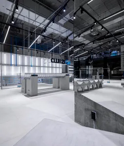 Modern storefront with concrete elements and industrial-style lighting.