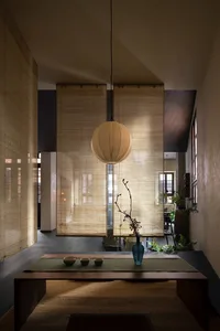 Minimalist living room featuring bamboo furniture and natural light from large windows.