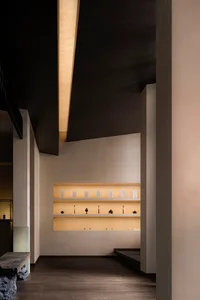 Modern retail shop interior with white concrete display shelves and yellow lighting.