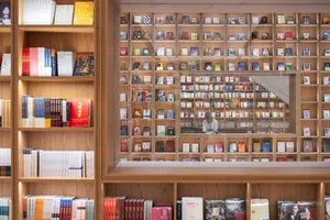 Modern bookstore interior with wooden shelves filled with books.