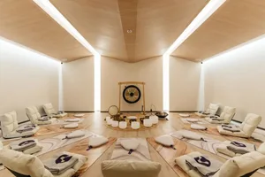 A minimalist yoga studio with wooden flooring and white accents.