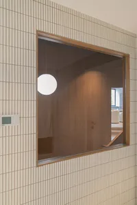 現代簡約玄關，搭配木質門扇與白色圓形燈具。