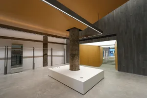 A minimalist commercial space featuring concrete and wood materials.