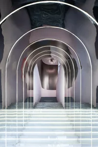 A modern, metallic architectural design featuring curved archways and stairs.