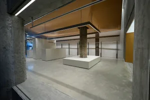 A modern office space featuring concrete flooring and glass partitions