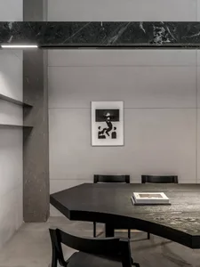 A minimalist black wooden table with a concrete wall background.