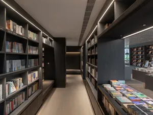 A modern bookstore featuring wooden shelves filled with books.