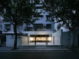 Modern building entrance featuring glass doors and illuminated interior