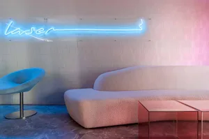 A modern interior design featuring a textured sofa and abstract lighting against a textured wall