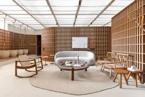 A modern living room with wooden furniture and grid-patterned walls, featuring a comfortable sofa, coffee table, and decorati
