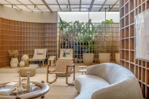 Modern living room with wooden accents, concrete floor, and fabric seating.