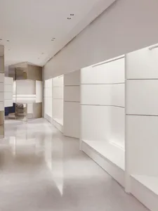 A minimalist modern corridor with white walls and a concrete floor