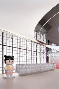 Modern minimalist retail space featuring metallic finishes and white grid windows.