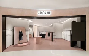 一間極簡時裝店，採用俐落現代設計，搭配粉紅色地板與黑白配色。