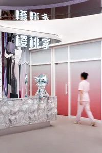 Modern, minimalist retail store with metallic sculptures and light-colored surfaces.