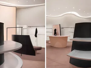 Modern retail space featuring a marble display table and metal shelving units.