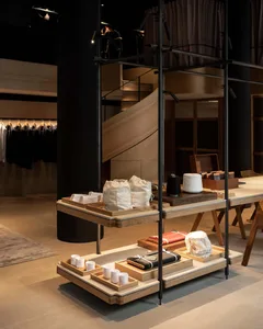 A modern retail shop displaying various accessories on shelves and tables, featuring wooden furniture and minimalist design.