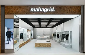 A modern minimalist retail storefront showcasing concrete and glass materials.