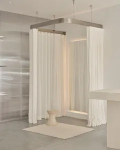 A minimalist space featuring concrete structures and white curtains.
