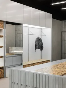 A modern clothing shop featuring minimalist design with metal, wood, and concrete materials.