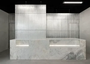 Modern industrial-style reception desk made of metal and marble materials.