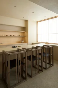 A modern kitchen bar area with wooden structures and black seating.