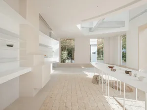 Modern kitchen interior featuring concrete countertops and wooden cabinets.