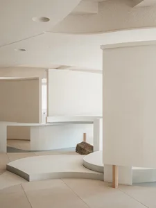 現代簡約的室內空間，設有混凝土休憩區，搭配曲線建築元素與天然石材。