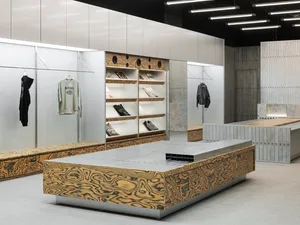 Concrete shelving with clothing and accessories in a modern retail store.