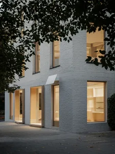 Modern storefront featuring illuminated doors and windows with white-brick facade.