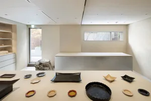 A display of ceramic tableware on a light-colored table against a light wall background.